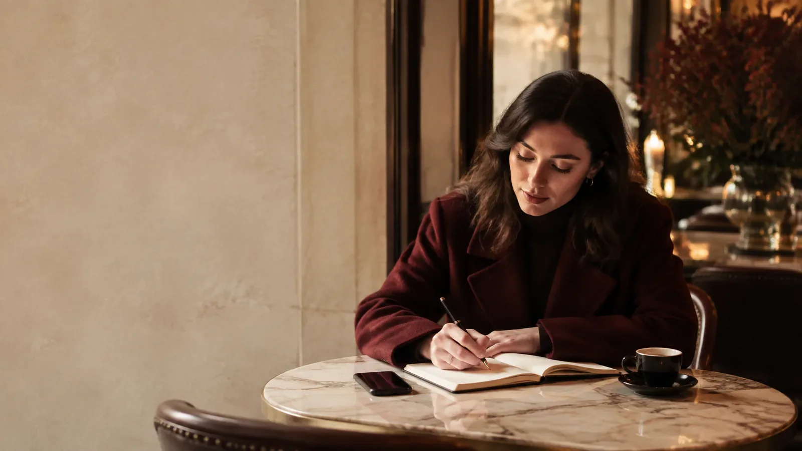 A woman writing a thoughtful note at a quiet cafe